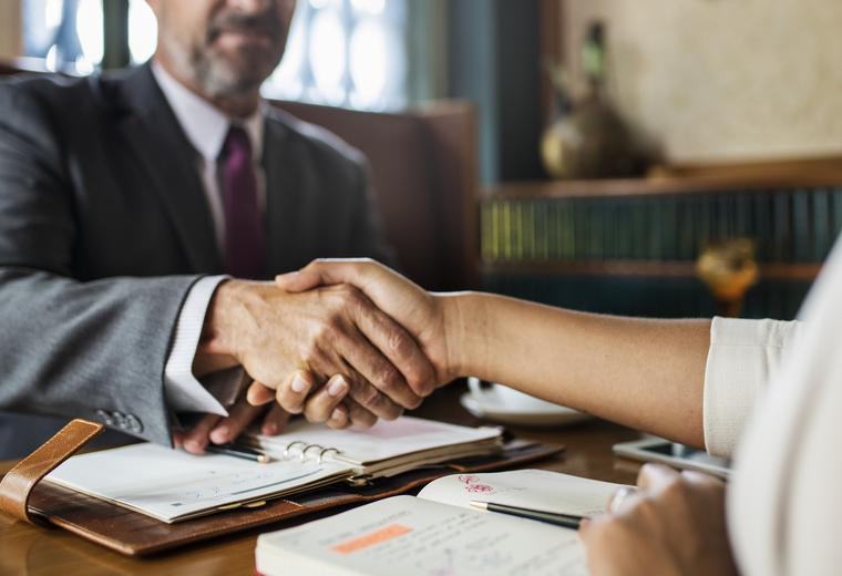 Attorney and client shaking hands over documents